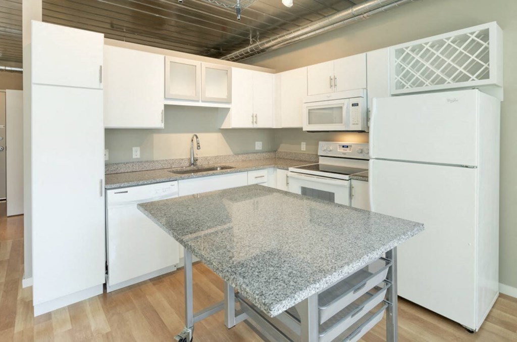 a kitchen with a granite counter top and white appliances at Ann Arbor City Club, Ann Arbor Michigan
